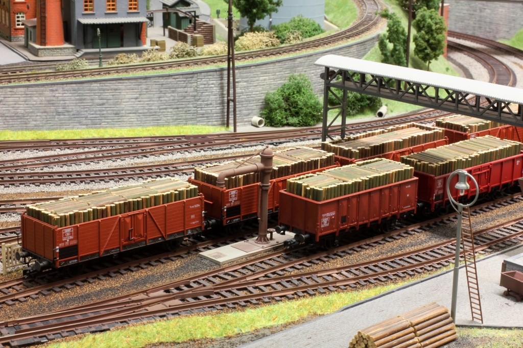 Modélisme ferroviaire d'ambiance : wagons chargés de bois sur voies de débord.